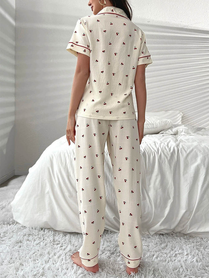 Conjunto de pijama con pantalones y blusa con ribetes en contraste con estampado de cerezas