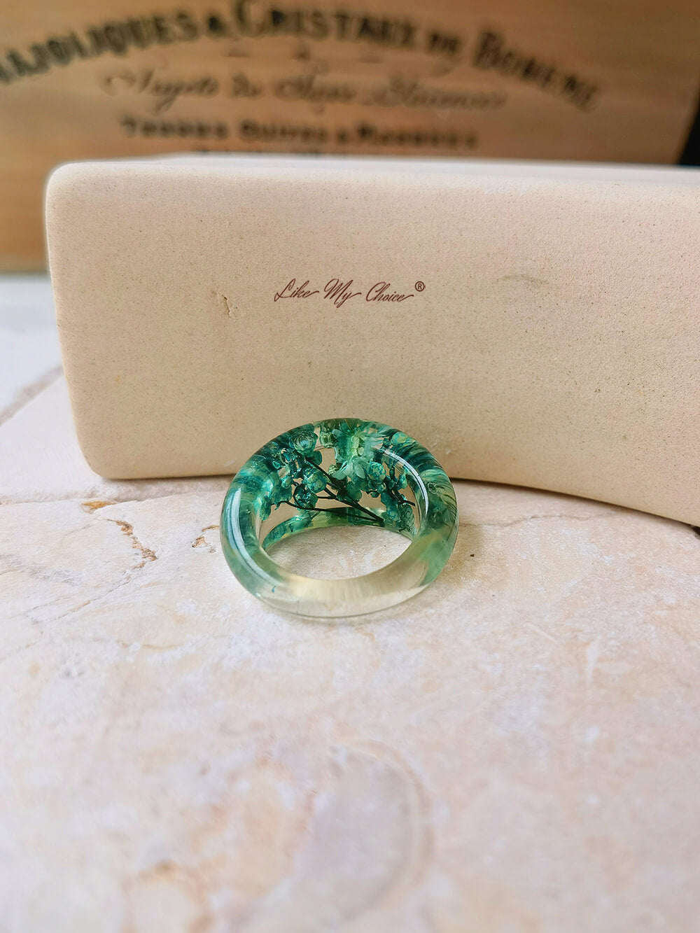 Ring aus getrocknetem Blumenharz mit grünen Blüten